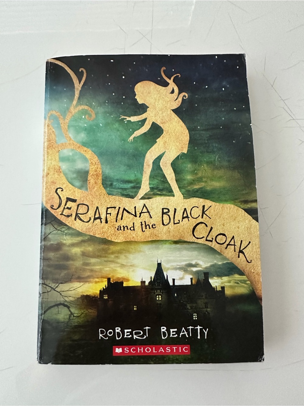 Scholastic paperback - Gold silhouette on green and black cover